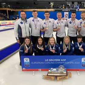Team Scotland show off their gold medals alongside the women's team/