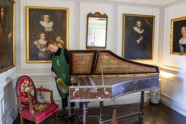 Housekeeper Lucy Whiteman dusts a harpsicord in the High Drawing Room.