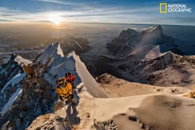 As the sun rises above the Tibetan Plateau, Pasang Kaji Sherpa (front) and Lhakpa Tenje Sherpa pass 28,700 feet on Mount Everest. The big question: Did George Mallory and Sandy Irvine get this far — or perhaps reach the top — in 1924? (PIC: Renan Ozturk/National Geographic)