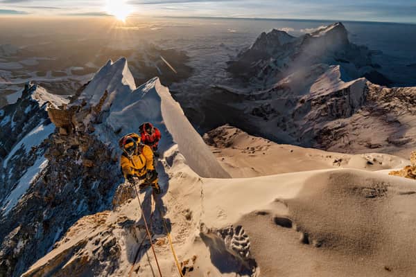 As the sun rises above the Tibetan Plateau, Pasang Kaji Sherpa (front) and Lhakpa Tenje Sherpa pass 28,700 feet on Mount Everest. The big question: Did George Mallory and Sandy Irvine get this far — or perhaps reach the top — in 1924? (PIC: Renan Ozturk/National Geographic)