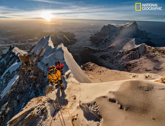 As the sun rises above the Tibetan Plateau, Pasang Kaji Sherpa (front) and Lhakpa Tenje Sherpa pass 28,700 feet on Mount Everest. The big question: Did George Mallory and Sandy Irvine get this far — or perhaps reach the top — in 1924? (PIC: Renan Ozturk/National Geographic)