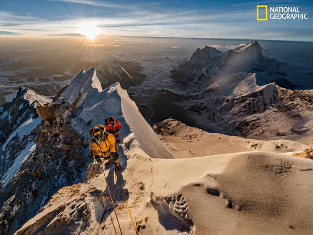 As the sun rises above the Tibetan Plateau, Pasang Kaji Sherpa (front) and Lhakpa Tenje Sherpa pass 28,700 feet on Mount Everest. The big question: Did George Mallory and Sandy Irvine get this far — or perhaps reach the top — in 1924? (PIC: Renan Ozturk/National Geographic)