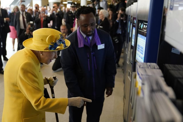 Queen Elizabeth II using a oyster card machine at Paddington station in London.