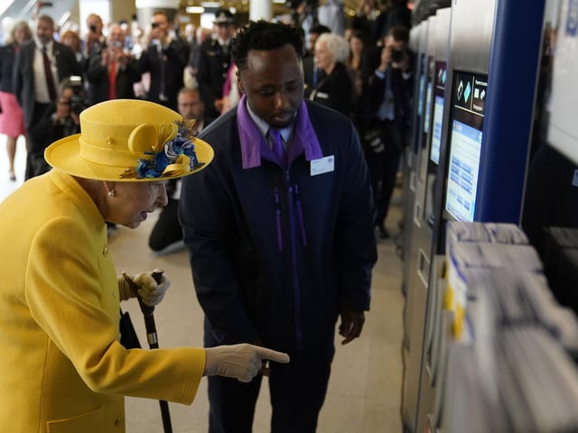 Queen Elizabeth II using a oyster card machine at Paddington station in London.