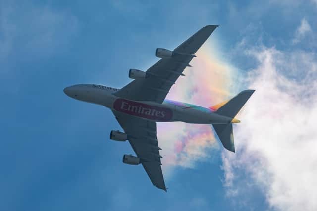 A stunning series of photos have captured rare 'rainbow' vapour trails behind a plane as it came to land at Manchester Airport. See SWNS story SWNAvapour. The snaps, taken from a photographer's back garden in Cheshire, show the Emirates airliner's technicolour trails illuminating the sky in dazzling shades. Scientists from NASA say ice crystals form when cold air condenses around particles from the plane’s exhaust. The sunlight catching these crystals is reflected back at a range of angles leading to a stunning spread of colours across the light spectrum.