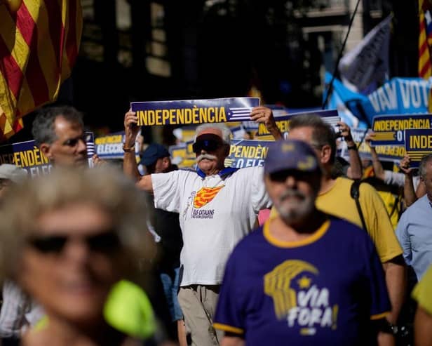 A protestor holds a sign reading "independence" during a demonstration last year marking the sixth anniversary of a self-determination referendum organised by Catalan separatists despite being banned by the courts, in Barcelona.