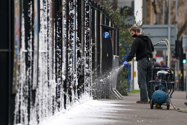 A set dresser sprays fake snow on the set in Glasgow (Photo: Andrew Milligan/PA Wire).