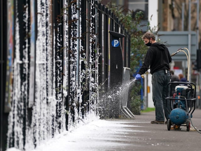 A set dresser sprays fake snow on the set in Glasgow (Photo: Andrew Milligan/PA Wire).