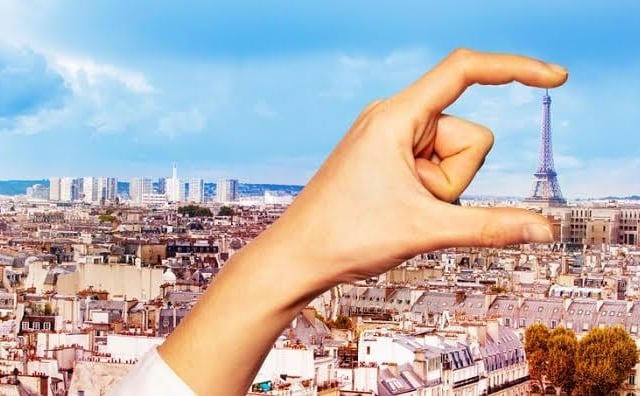 Is the hand giant, or is it just far away from the Eiffel tower? This is a very popular optical illusion trick tourists love to do with famous landmarks! This is a perspective illusion, if we were further to the left or right in this scene, we would see that the hand is much further away from the building.