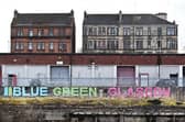 John Devlin 15/03/2022 . GLASGOW. Govan. Govan Graving Docks.
A new sign saying Blue Green Glasgow can be seen in Govan Graving Docks.
The sign has been catching the eye of passing Glaswegians who have confessed of being confused by it's meaning. Glasgow's 2 famous clubs Celtic (green) and Rangers (blue) wear these colours.
The sign is actually for the BLUE GREEN GLASGOW PROJECT
Blue Green Glasgow CIC is a community interest company restoring post-industrial land in Glasgow by building wetland, or blue-green, ecosystems for climate adaptation, engaging communities, and the creation of sustainable jobs.
The organisation is affiliated with the Blue Green Carbon programme, a platform for environmental restoration through carbon offset activities.
The organisation’s Govan Wetland Project sits in the heart of Glasgow, right across the river from COP26, and makes up a 5-acre wetland restoration site where coastal wetland ecosystems are being built to capture carbon, rehabilitate soils, and support wildlife. The site also features regenerative farming practices that put nature at the heart of food production.