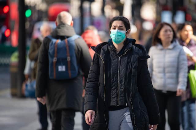 A woman wearing protective face masks on Oxford Street, central London.