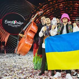 Members of the band "Kalush Orchestra" pose onstage with the winner's trophy and Ukraine's flags after winning on behalf of Ukraine the Eurovision Song contest in Turin. (Photo by Marco BERTORELLO / AFP) (Photo by MARCO BERTORELLO/AFP via Getty Images)