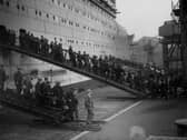 Some of the hundreds of workers employed on the construction of the Cunard liner Queen Mary at John Brown's shipyard, Clydebank, leaving the vessel at lunchtime, circa 1935  (Picture: General Photographic Agency/Getty Images)