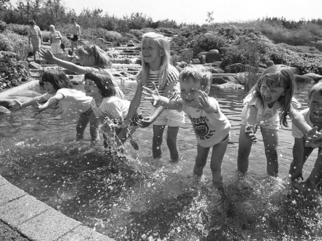 Children from Crookfur primary school cool off in the waterfall when temperatures hit 75 F (23 °C) at Glasgow Garden Festival, June 1988.