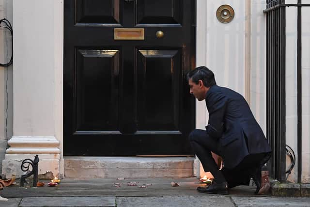 Rishi Sunak lighting candles outside 11 Downing Street, London, ahead of Diwali celebrations.