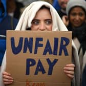 A demonstrator holds a placard during a protest by junior doctors (Picture: Daniel Leal/AFP via Getty Images)