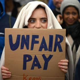 A demonstrator holds a placard during a protest by junior doctors (Picture: Daniel Leal/AFP via Getty Images)