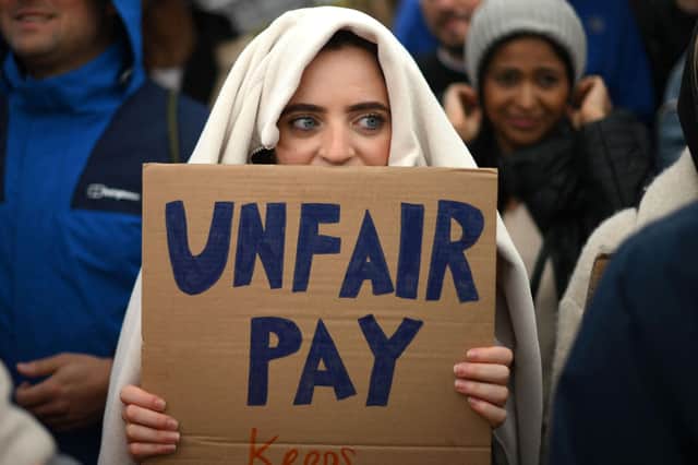 A demonstrator holds a placard during a protest by junior doctors (Picture: Daniel Leal/AFP via Getty Images)