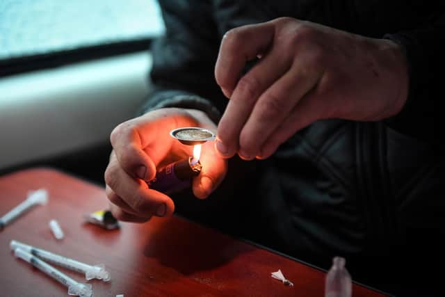 A drug user prepares and injects heroine. Picture: ANDY BUCHANAN/AFP via Getty Images