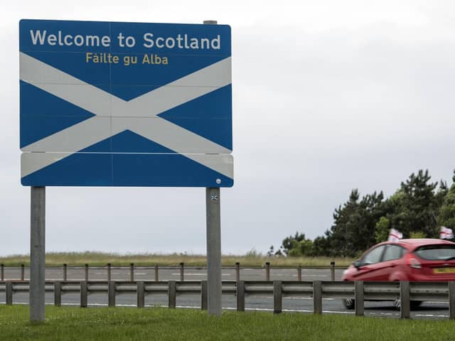 A car adorned with St George's Cross flags passes a welcome sign as it crosses the border into Scotland near Berwick-upon-Tweed. Picture: AFP via Getty Images