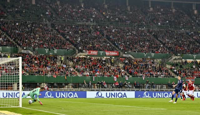 Lyndon Dykes fires home Scotland's penalty in Vienna.
