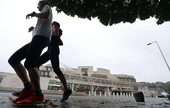 Runners jog past the Scottish Parliament in Edinburgh. Picture: Chris Ratcliffe/Bloomberg via Getty Images