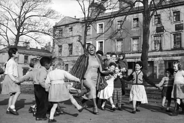 Sister Rosetta Tharpe with a group of children in the Tiger Bay area of Cardiff in December 1957 (Picture: Chris Ware/Keystone Features/Hulton Archive/Getty Images)
