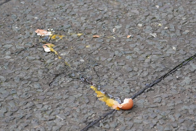 A broken egg on the street after it was thrown at King Charles III and the Queen Consort