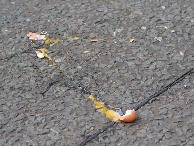 A broken egg on the street after it was thrown at King Charles III and the Queen Consort