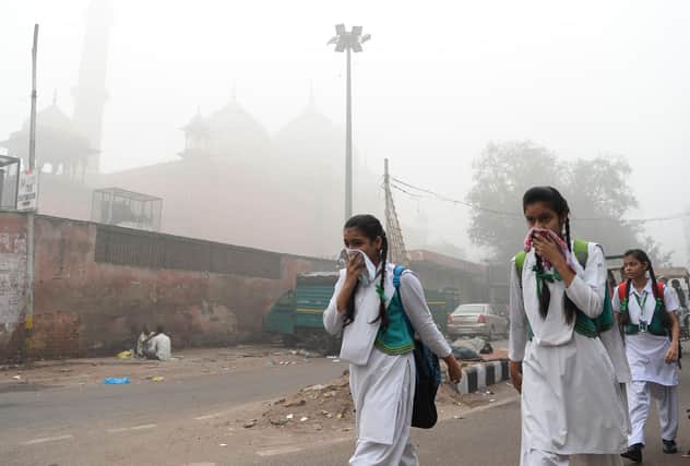 Schoolchildren cover their faces amid heavy smog in New Delhi, the world's most polluted capital (Picture: Sajjad Hussain/AFP via Getty Images)