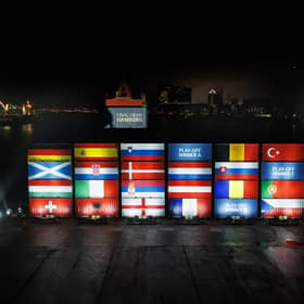 Stacked containers in the arrangement of the final draw stand at a terminal in the port of Hamburg at Elbphilharmonie, with the saltire shining bright.