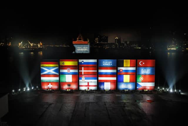 Stacked containers in the arrangement of the final draw stand at a terminal in the port of Hamburg at Elbphilharmonie, with the saltire shining bright.