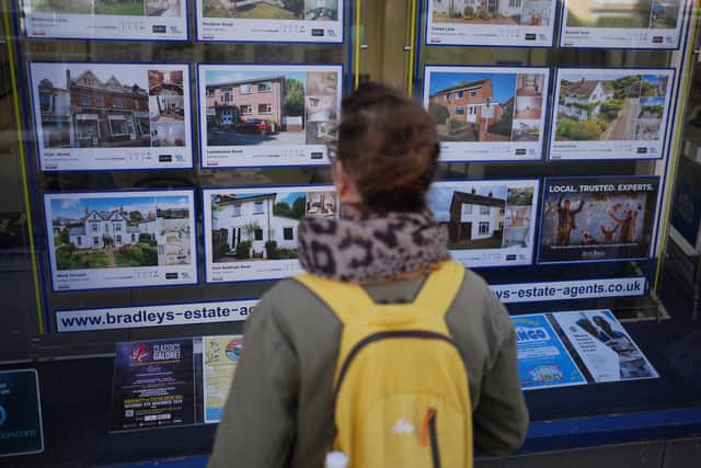 People looking at signs in an estate agent window