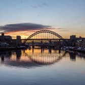 The Tyne Bridge on Newcastle Quayside at sunset, reflecting in the almost still River Tyne beneath