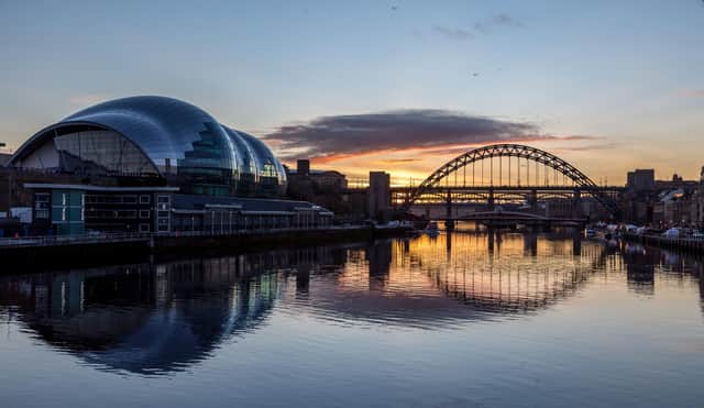 The Tyne Bridge on Newcastle Quayside at sunset, reflecting in the almost still River Tyne beneath