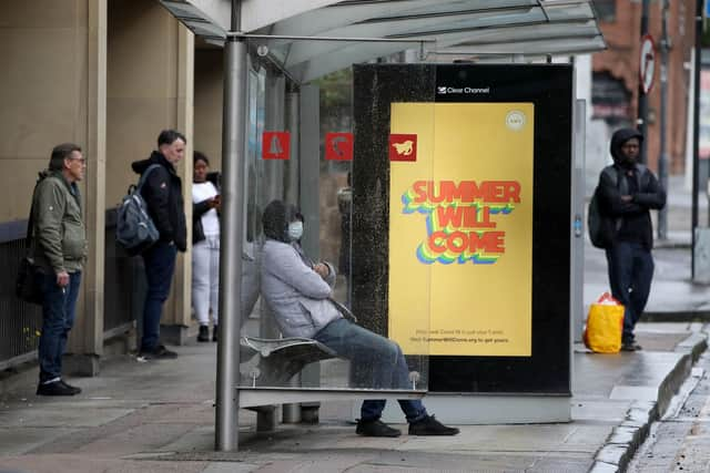 People wait at a bus stop in Glasgow. Picture: Andrew Milligan/PA Wire