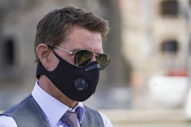 Tom Cruise wears a Covid face mask as he greets fans during a break from shooting Mission Impossible 7 on Rome's Fori Imperiali avenue in October (Picture: Andrew Medichini/AP)