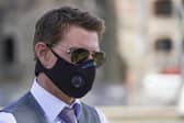 Tom Cruise wears a Covid face mask as he greets fans during a break from shooting Mission Impossible 7 on Rome's Fori Imperiali avenue in October (Picture: Andrew Medichini/AP)