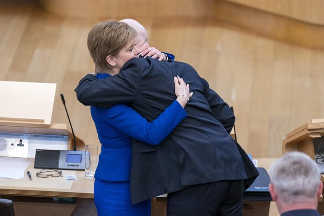 Outgoing First Minister Nicola Sturgeon and outgoing Deputy First Minister John Swinney hug before leaving the main chamber after her last First Minster's Questions (FMQs) in the main chamber of the Scottish Parliament in Edinburgh.