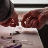 A drug user prepares heroin (Photo by Jeff J Mitchell/Getty Images)