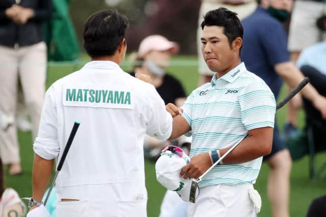 Hideki Matsuyama with his caddie after finishing on the 18th green in the third round of the Masters at Augusta National Golf Club. Picture: Kevin C. Cox/Getty Images.