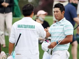 Hideki Matsuyama with his caddie after finishing on the 18th green in the third round of the Masters at Augusta National Golf Club. Picture: Kevin C. Cox/Getty Images.