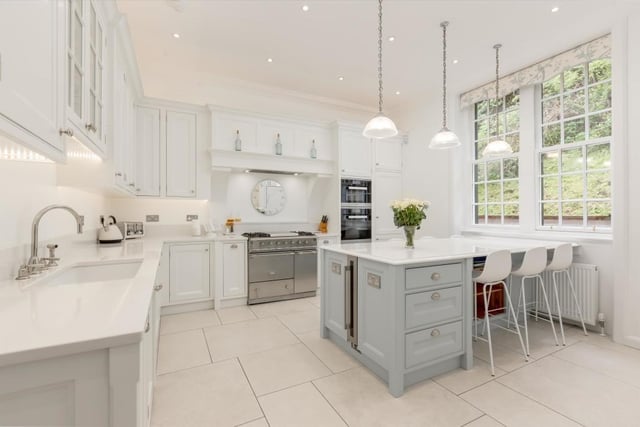 Refurbished kitchen with bespoke hand painted timber units, marble effect worktops, duel fuel range cooker, porcelain tiled flooring with underfloor heating, and integrated appliances.