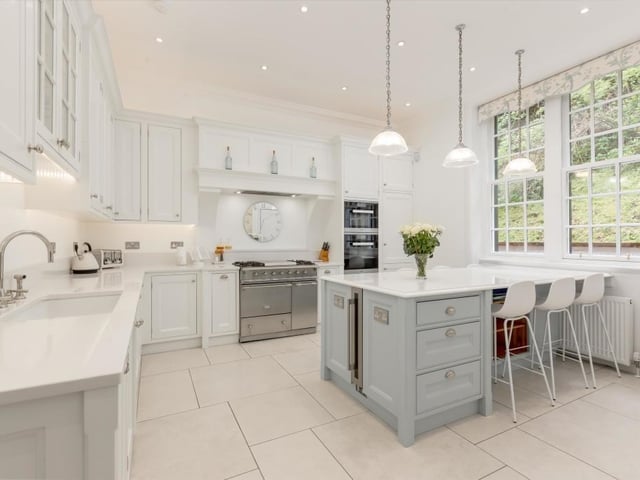 Refurbished kitchen with bespoke hand painted timber units, marble effect worktops, duel fuel range cooker, porcelain tiled flooring with underfloor heating, and integrated appliances.