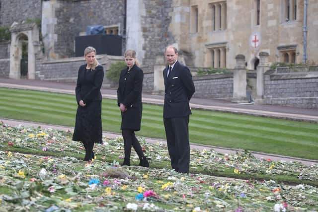 (left to right) The Countess of Wessex, Lady Louise Windsor and the Earl of Wessex view flowers outside St George's Chapel