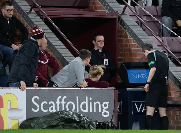 Referee Craig Napier goes to the VAR machine during a cinch Premiership match between Hearts and Livingston.