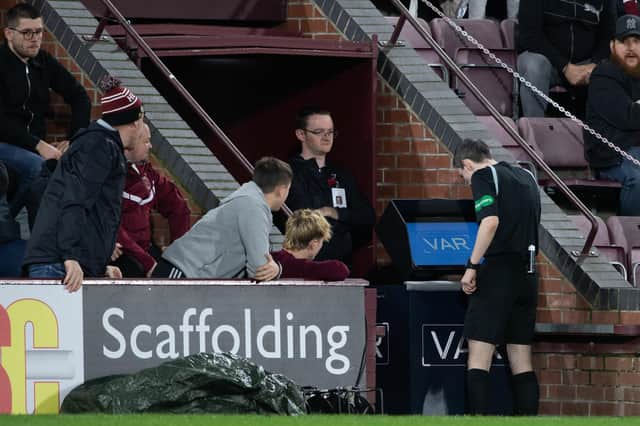 Referee Craig Napier goes to the VAR machine during a cinch Premiership match between Hearts and Livingston.