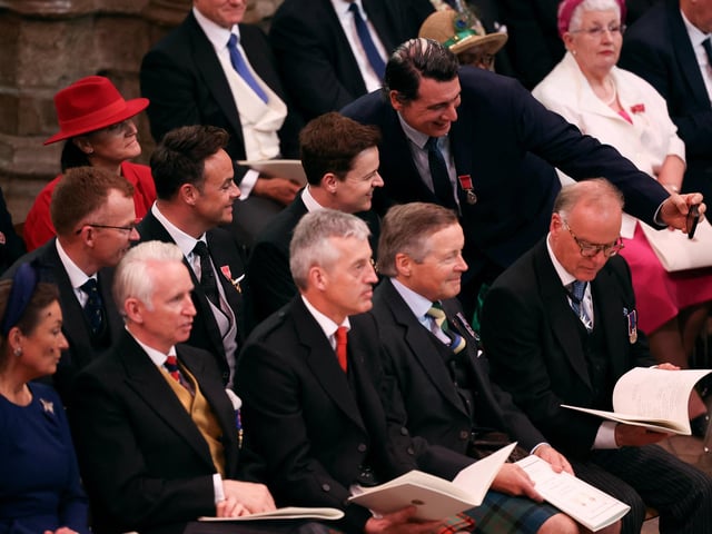 A guest takes pictures with Anthony McPartlin and Declan Donnelly ahead of the coronation of King Charles III and Queen Camilla at Westminster Abbey,