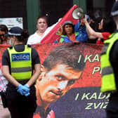Protestors hold placards up at a government detention centre where Serbia's tennis champion Novak Djokovic is reported to be staying in Melbourne. (Photo by WILLIAM WEST/AFP via Getty Images)