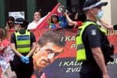 Protestors hold placards up at a government detention centre where Serbia's tennis champion Novak Djokovic is reported to be staying in Melbourne. (Photo by WILLIAM WEST/AFP via Getty Images)